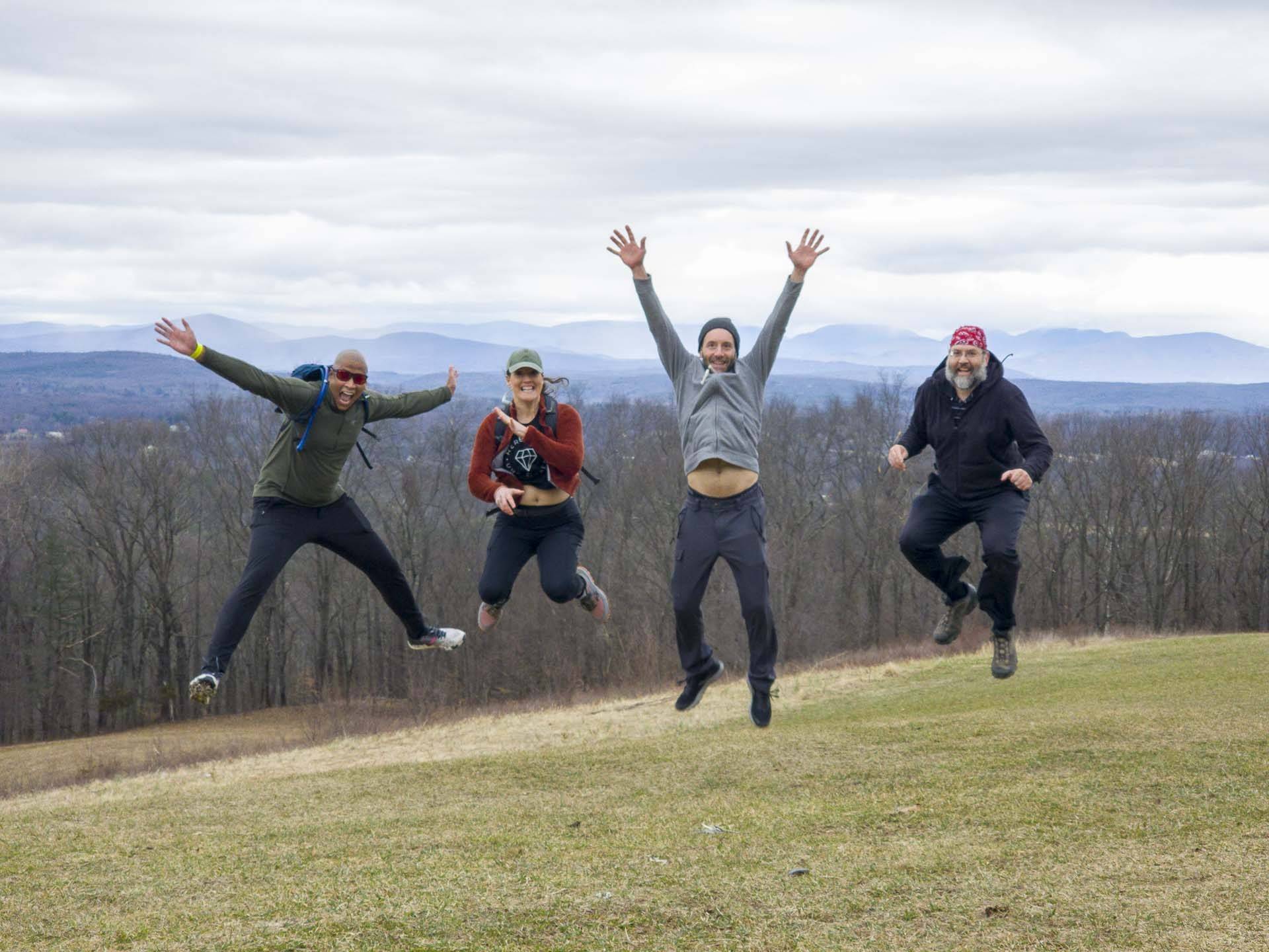 four people jumping in air