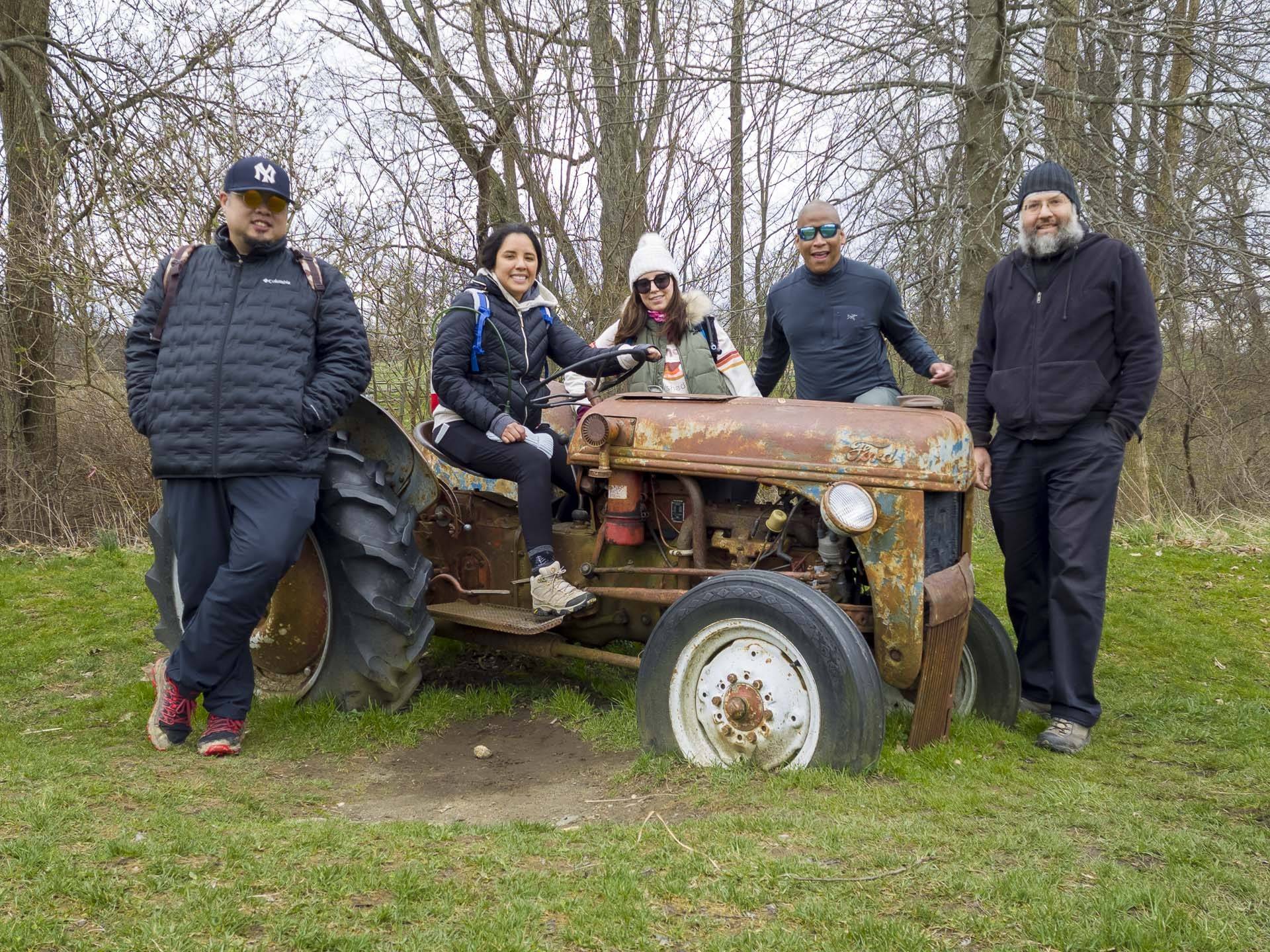 five surrounding a rusting tractor