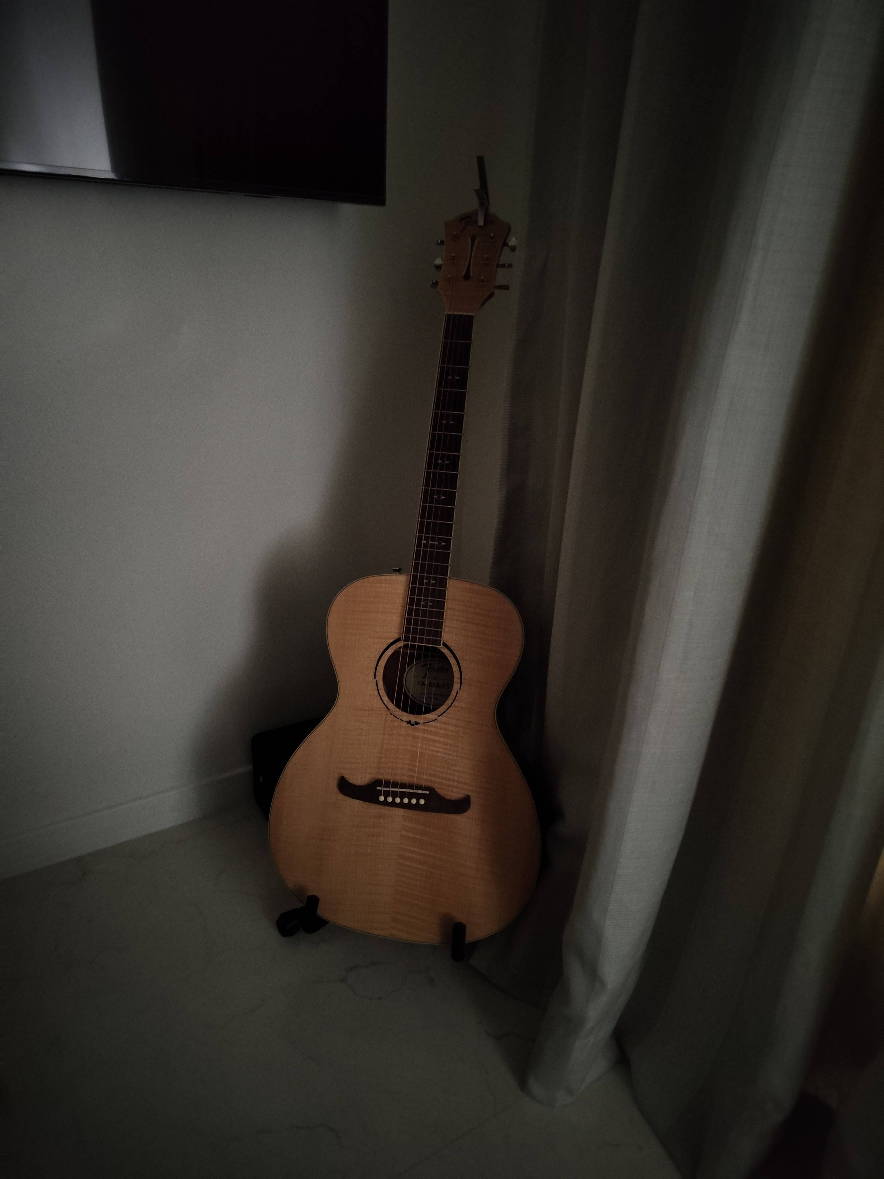 an image of a guitar placed in a dim room