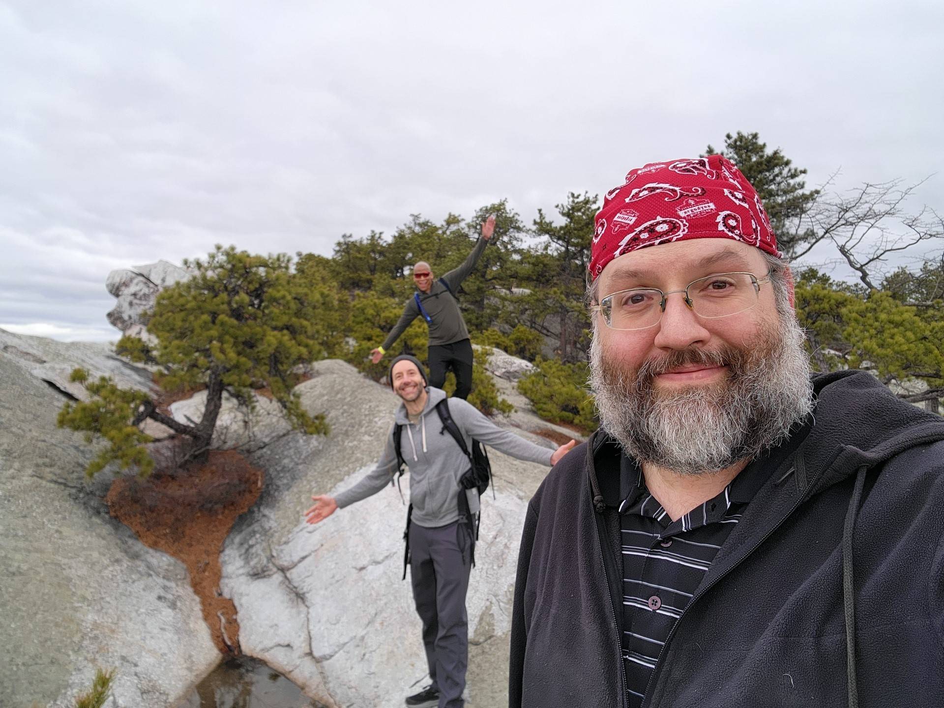 a selfie of three people on rocky terrain