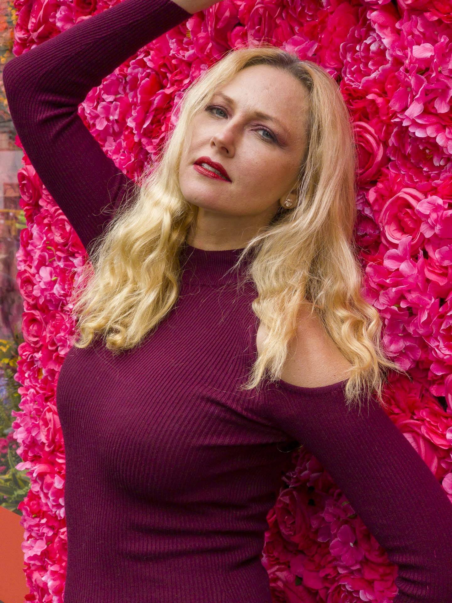 image of a lady in front of a flower wall