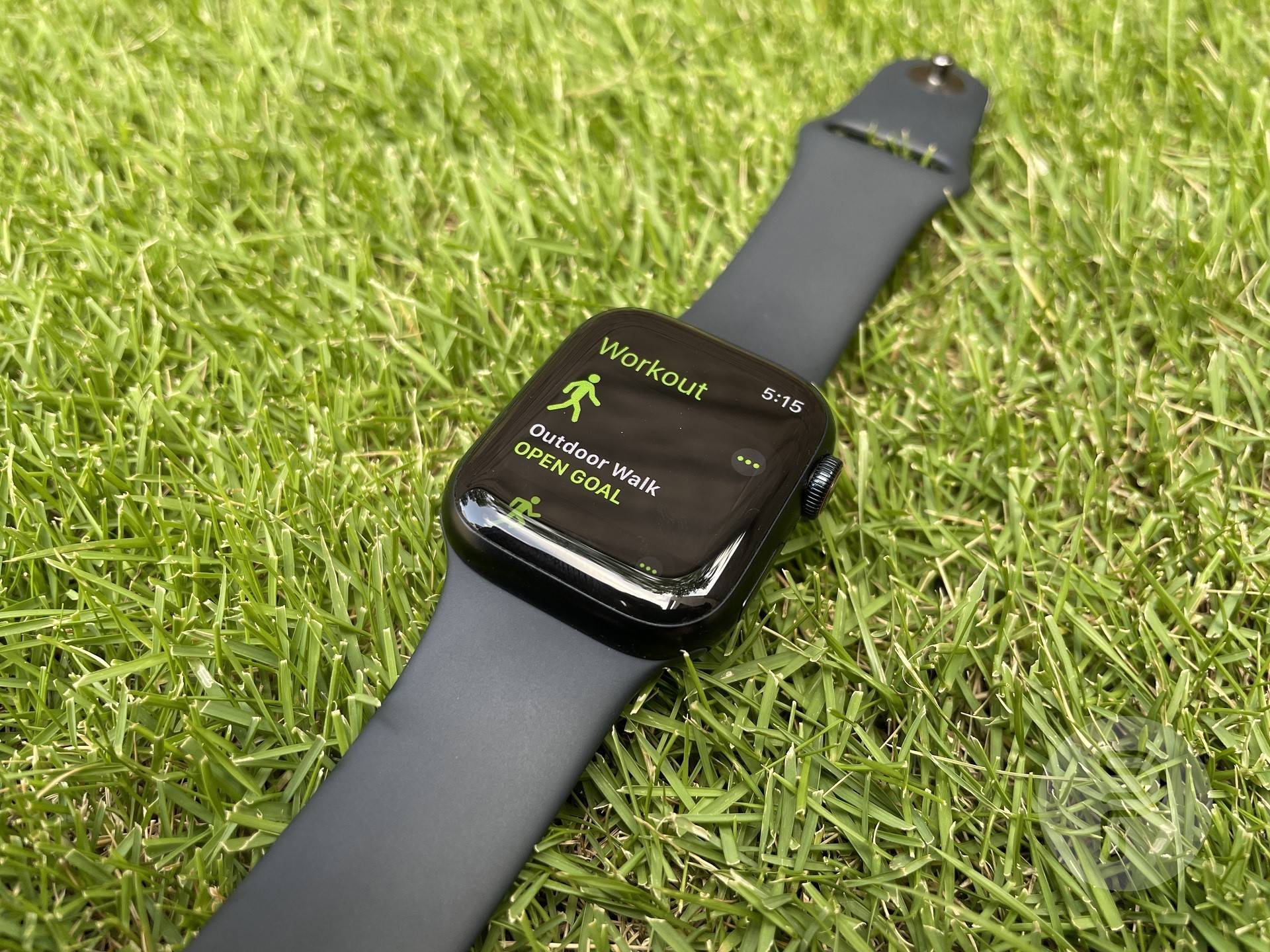 apple watch placed on the lawn with outdoor walk workout on screen