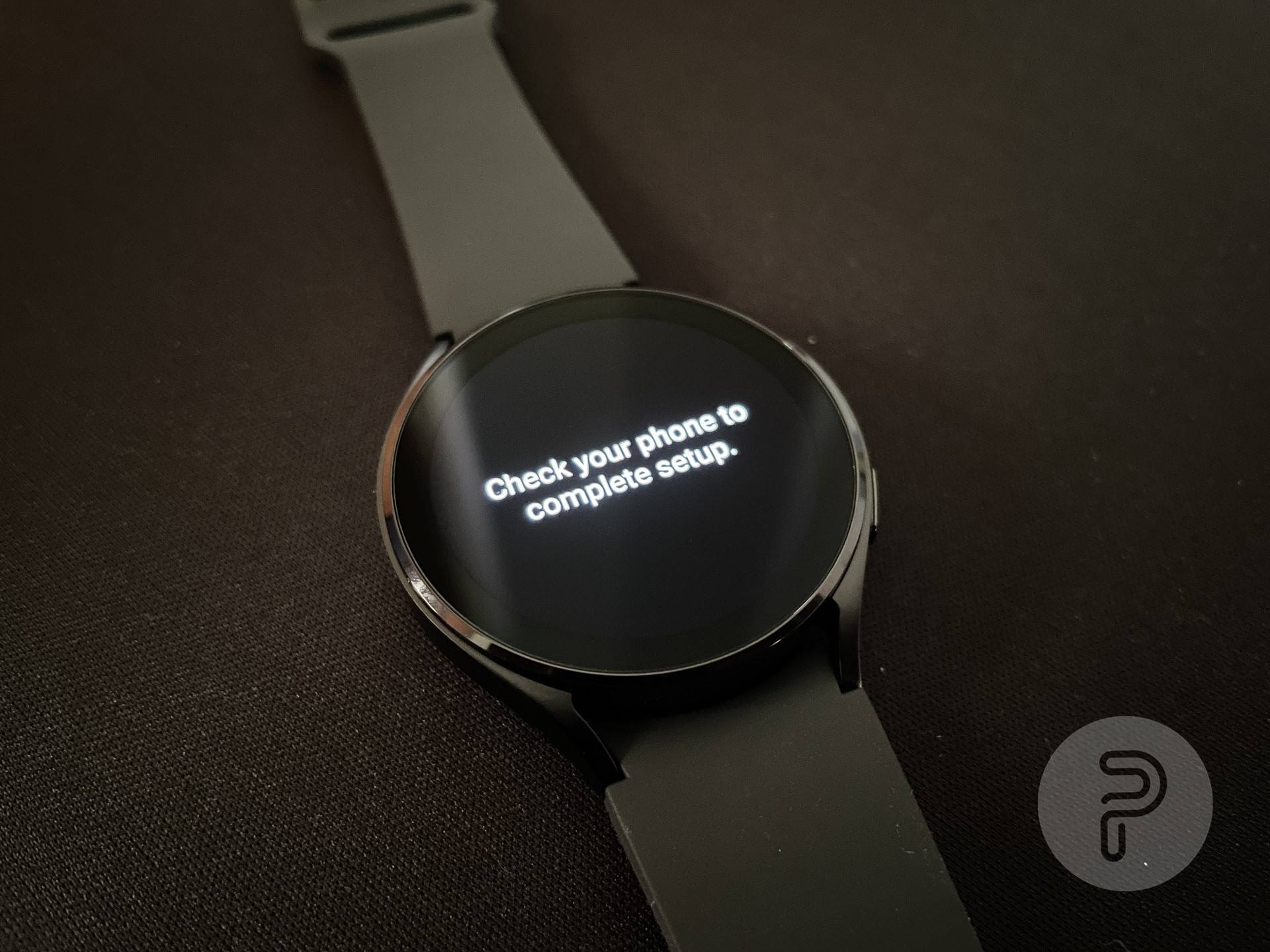 Galaxy Watch 4 placed on a mat with a setup step displayed on the screen