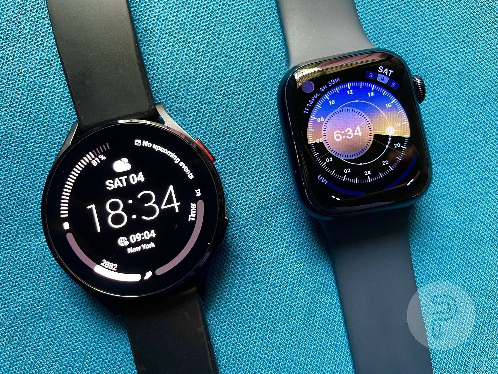 Galaxy Watch 4 and Apple Watch Series 7 placed on a fabric surface